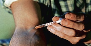 uomo che si inietta l'eroina