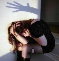 donna seduta per terra e maltrattata